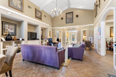 a large living room with purple furniture and a chandelier